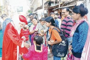 Former postal worker giving gifts to Santa Sage in Jalpaiguri town